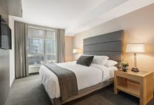 cozy bedroom on a budget with neutral bedding layered pillows and warm lighting