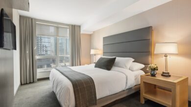 cozy bedroom on a budget with neutral bedding layered pillows and warm lighting