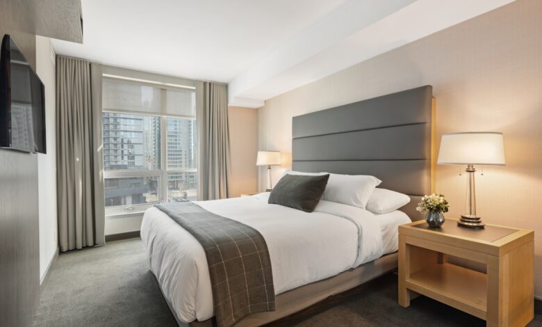 cozy bedroom on a budget with neutral bedding layered pillows and warm lighting