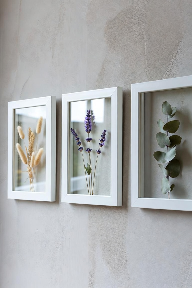 trio of white frames on wall each containing pressed dried botanicals pampas grass lavender eucalyptus
