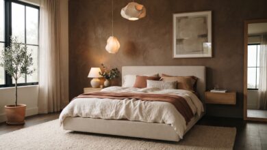 contemporary bedroom in warm oatmeal and clay tones with a sculptural pendant light