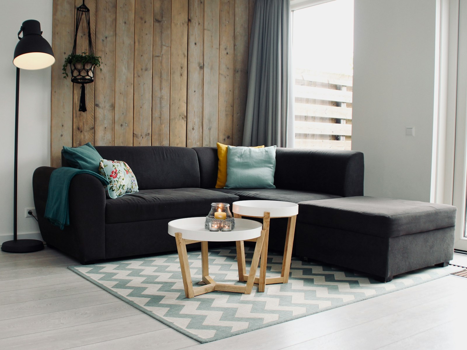 Candle on round white coffee table and sectional sofa