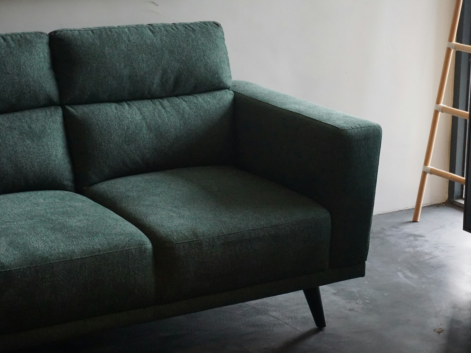 Gray cushion armchair beside white wall