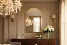 Gold arched mirror above a walnut sideboard in a formal dining room