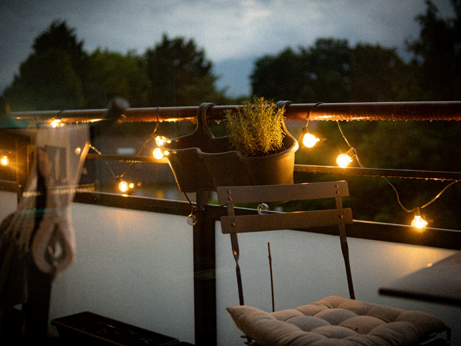 A balcony with a chair and a potted plant on it