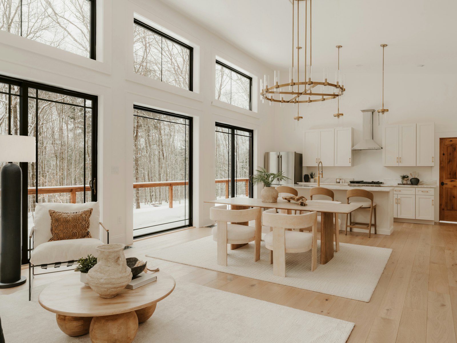 Modern living room with large windows overlooking a winter forest