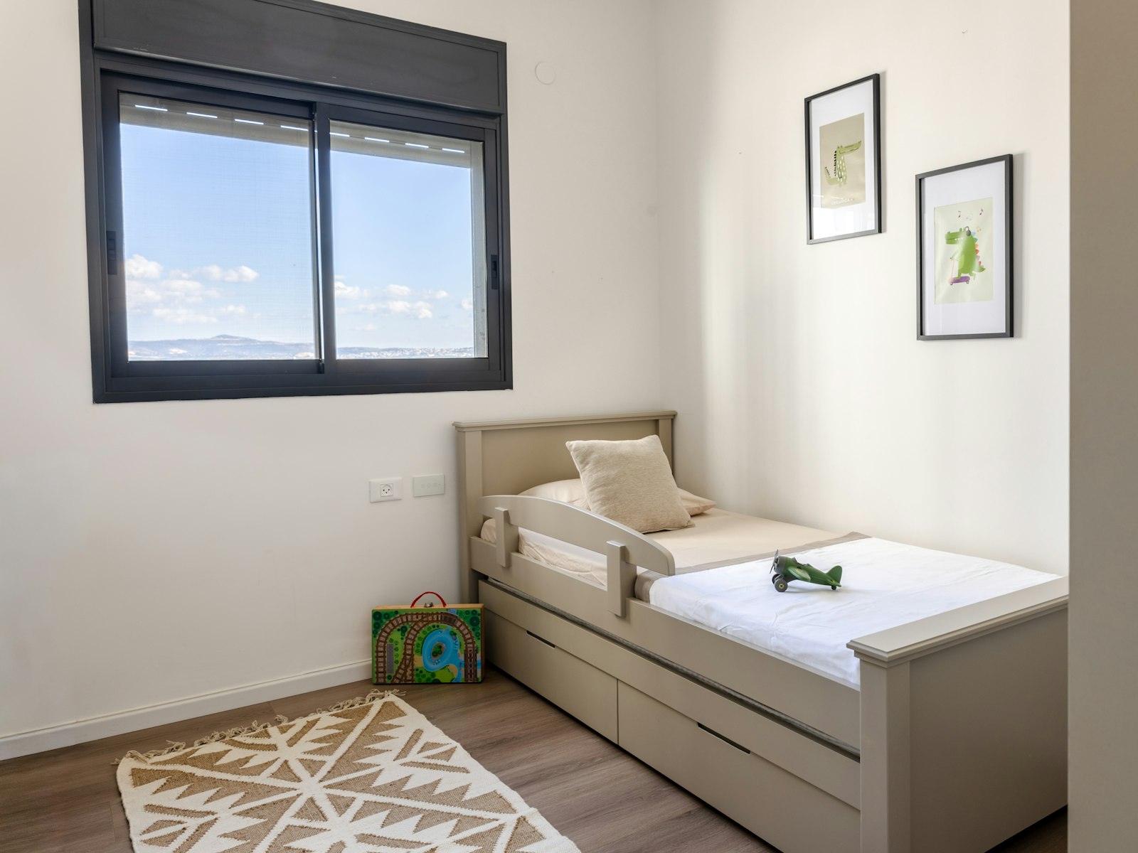 A child's bedroom with a twin bed and toys