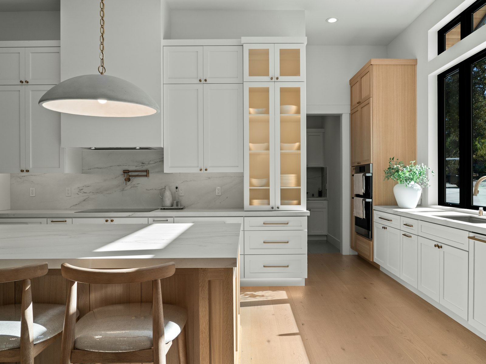 Modern white kitchen with island and large window