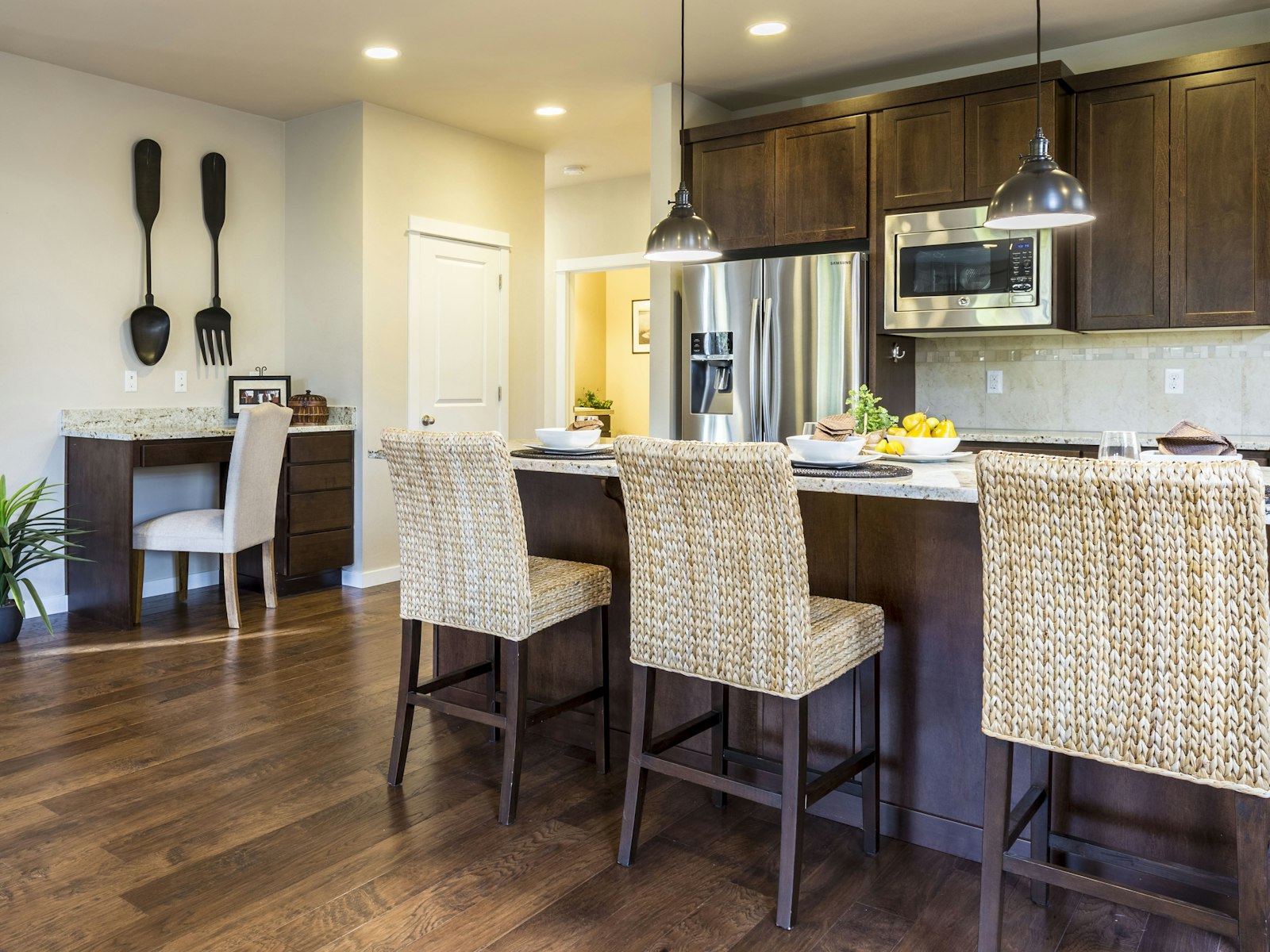 Three wooden chairs in front of kitchen counter