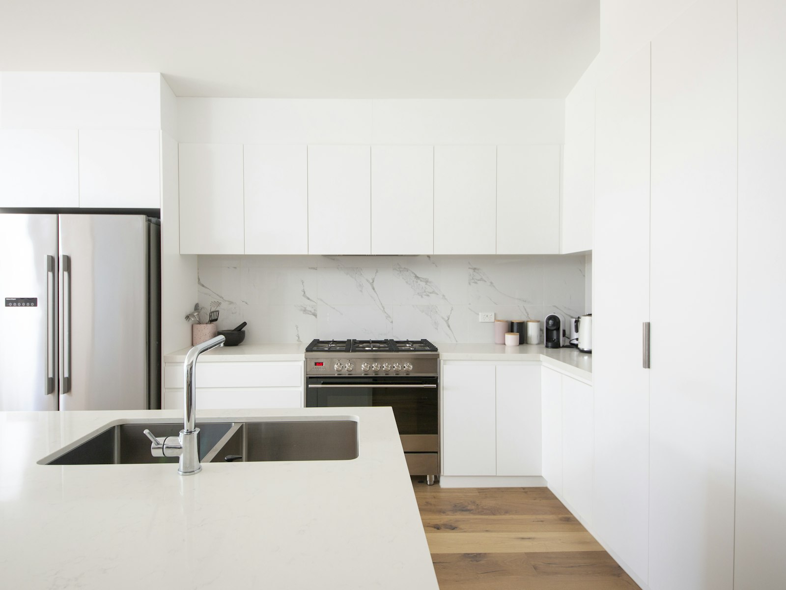 White kitchen cabinets over white counter