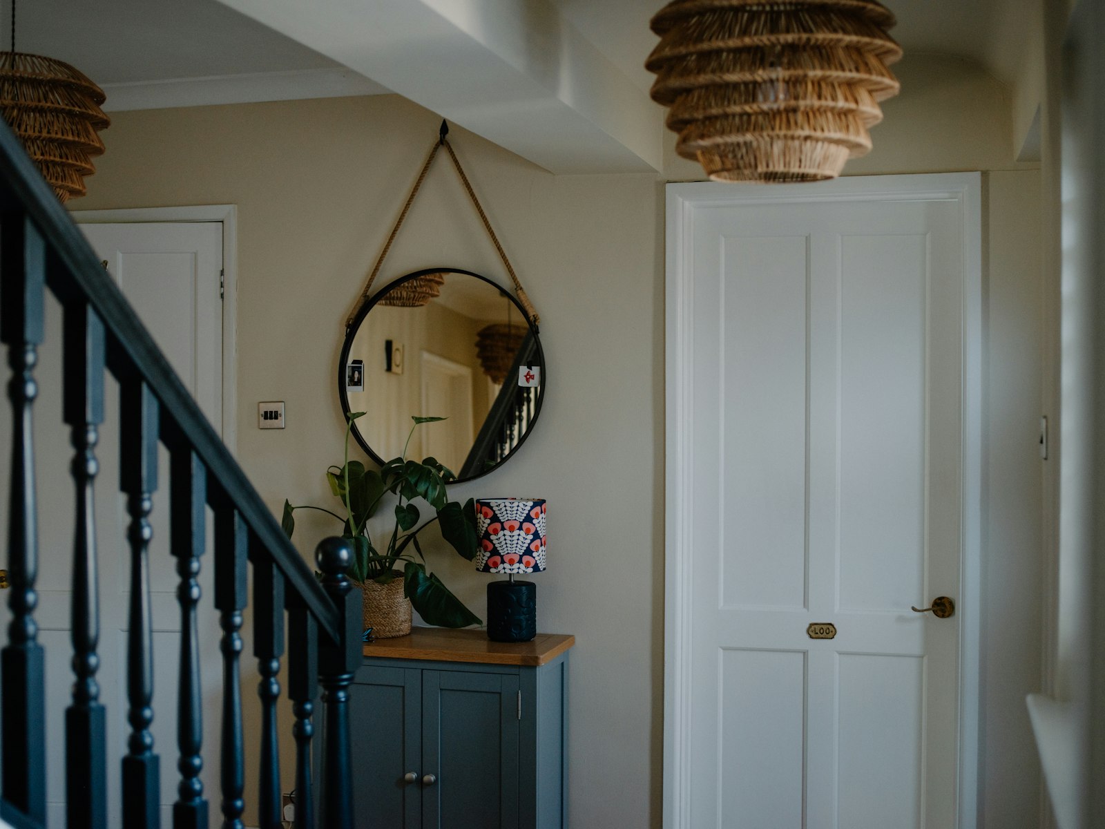 Hallway with staircase, mirror, and cabinet