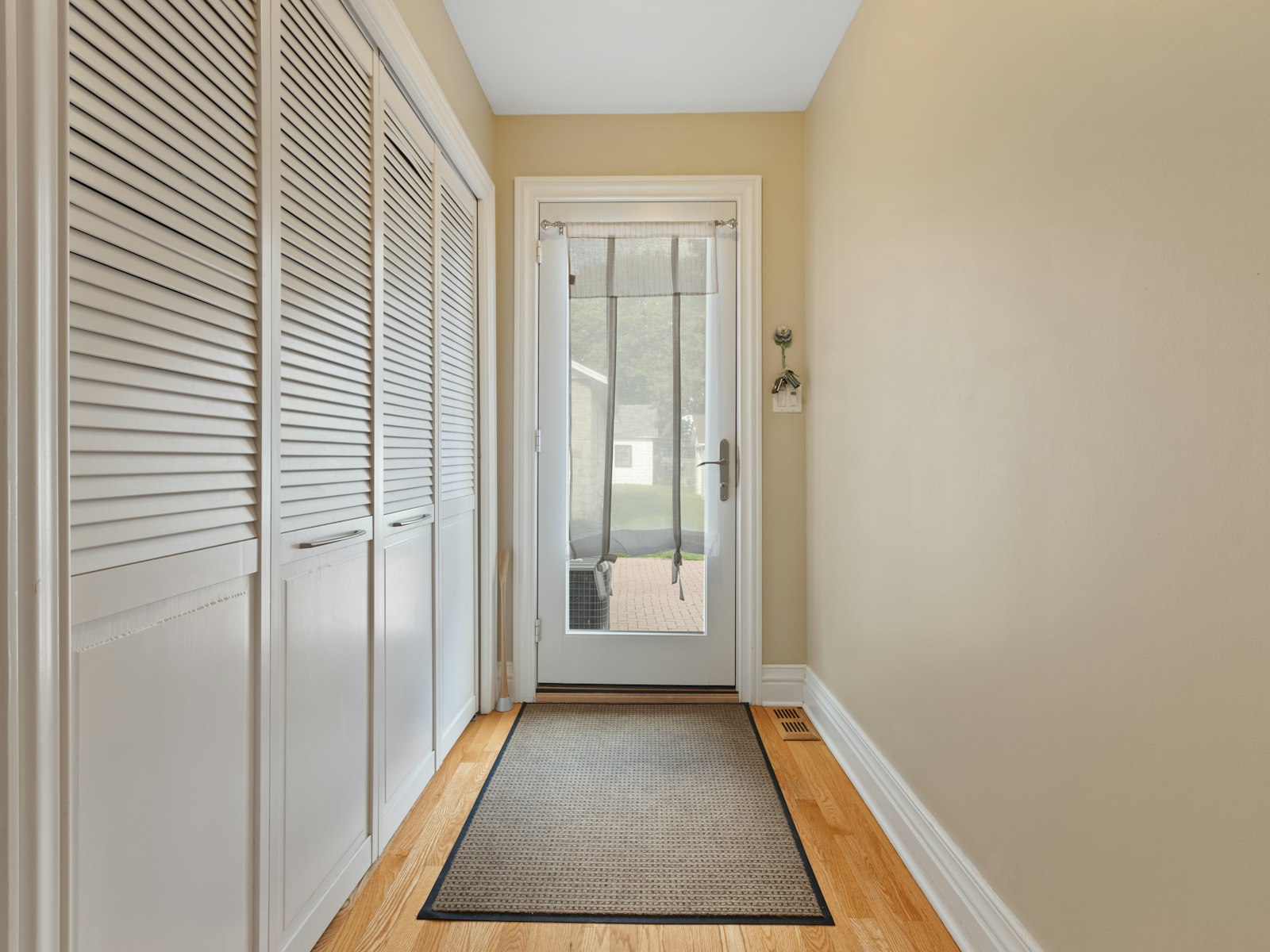 A hallway with a door and a rug on the floor