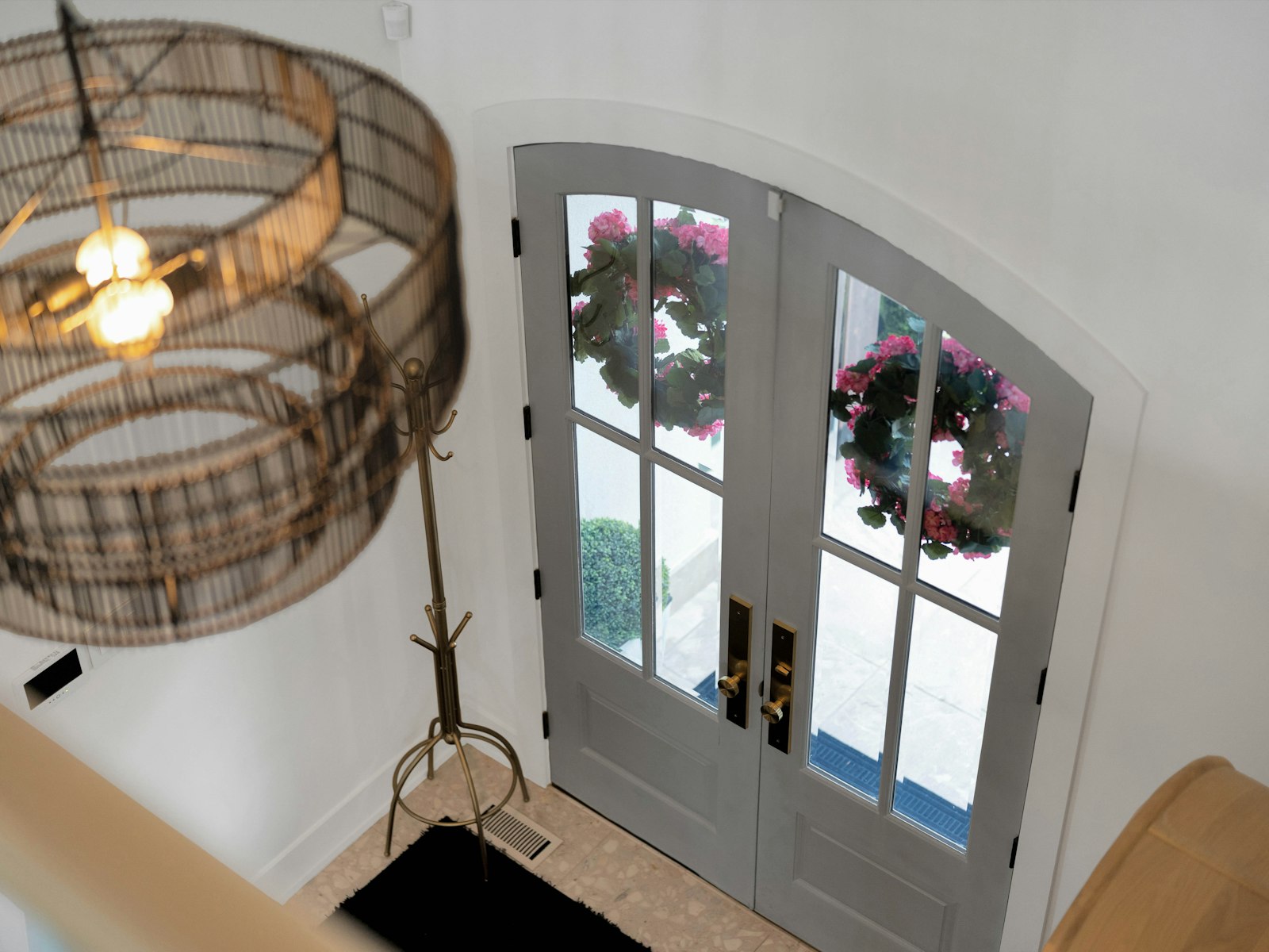 Entryway with double doors, wreaths, and a chandelier