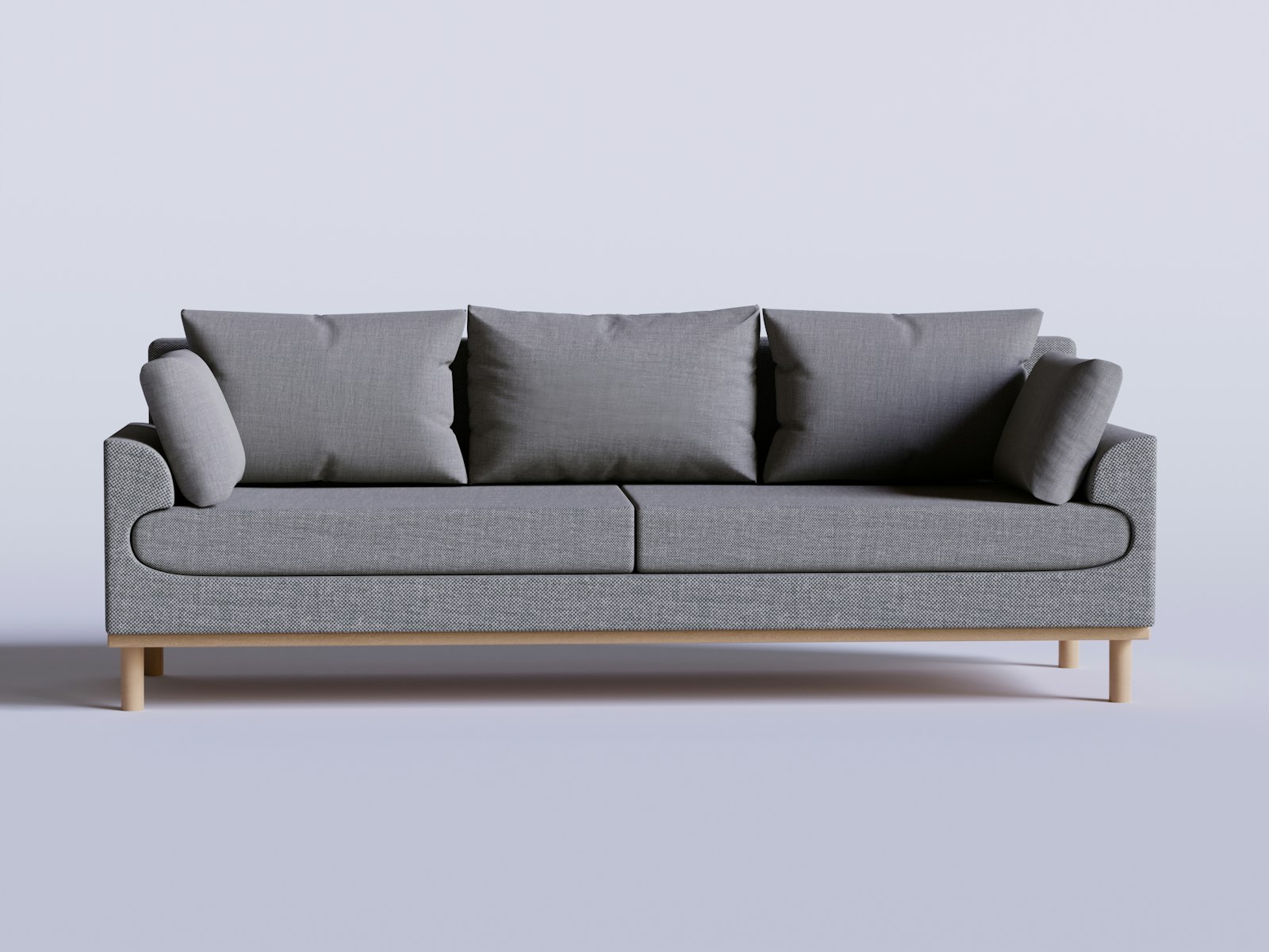 A gray couch with four pillows on it