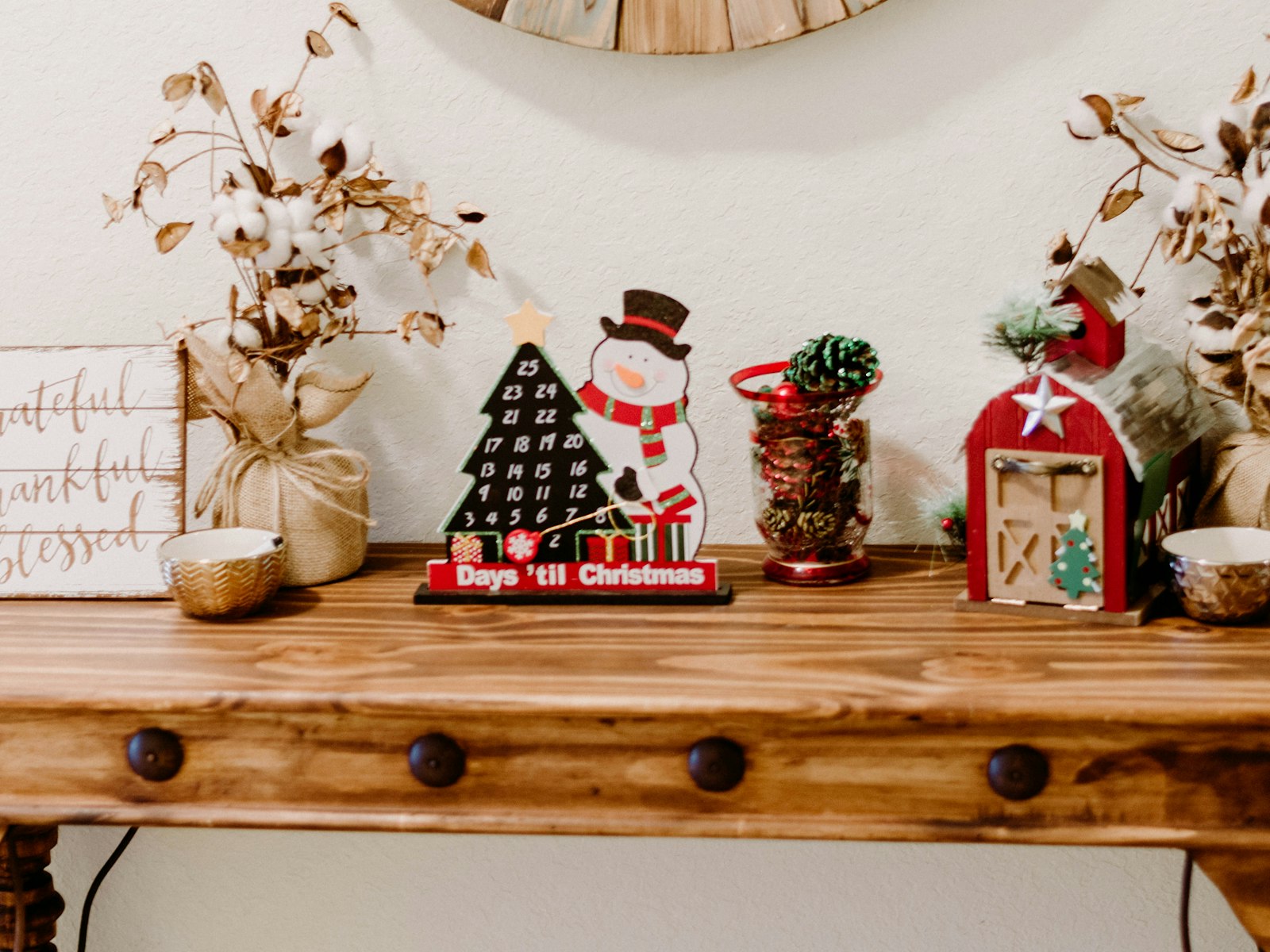 Wood console table styled with small Christmas decor and dried stems