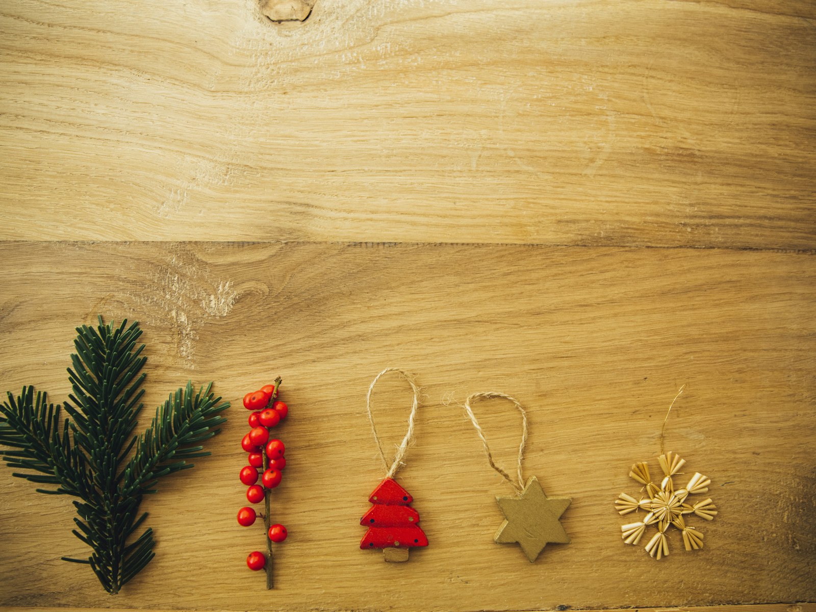 Five assorted Christmas tree decors on brown wooden surface – Christmas office decor idea