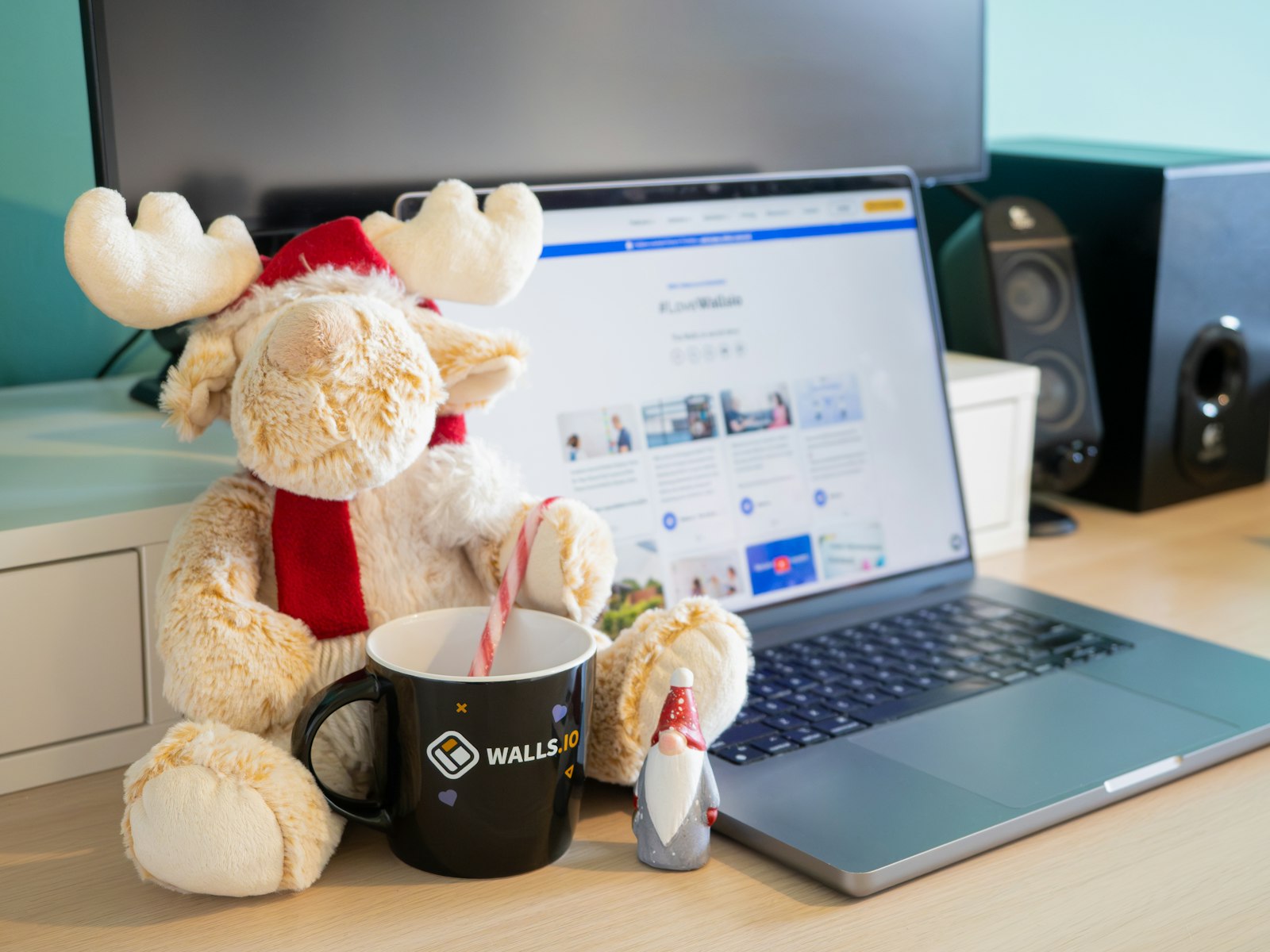 A stuffed moose sitting next to a laptop computer – Christmas office decor idea