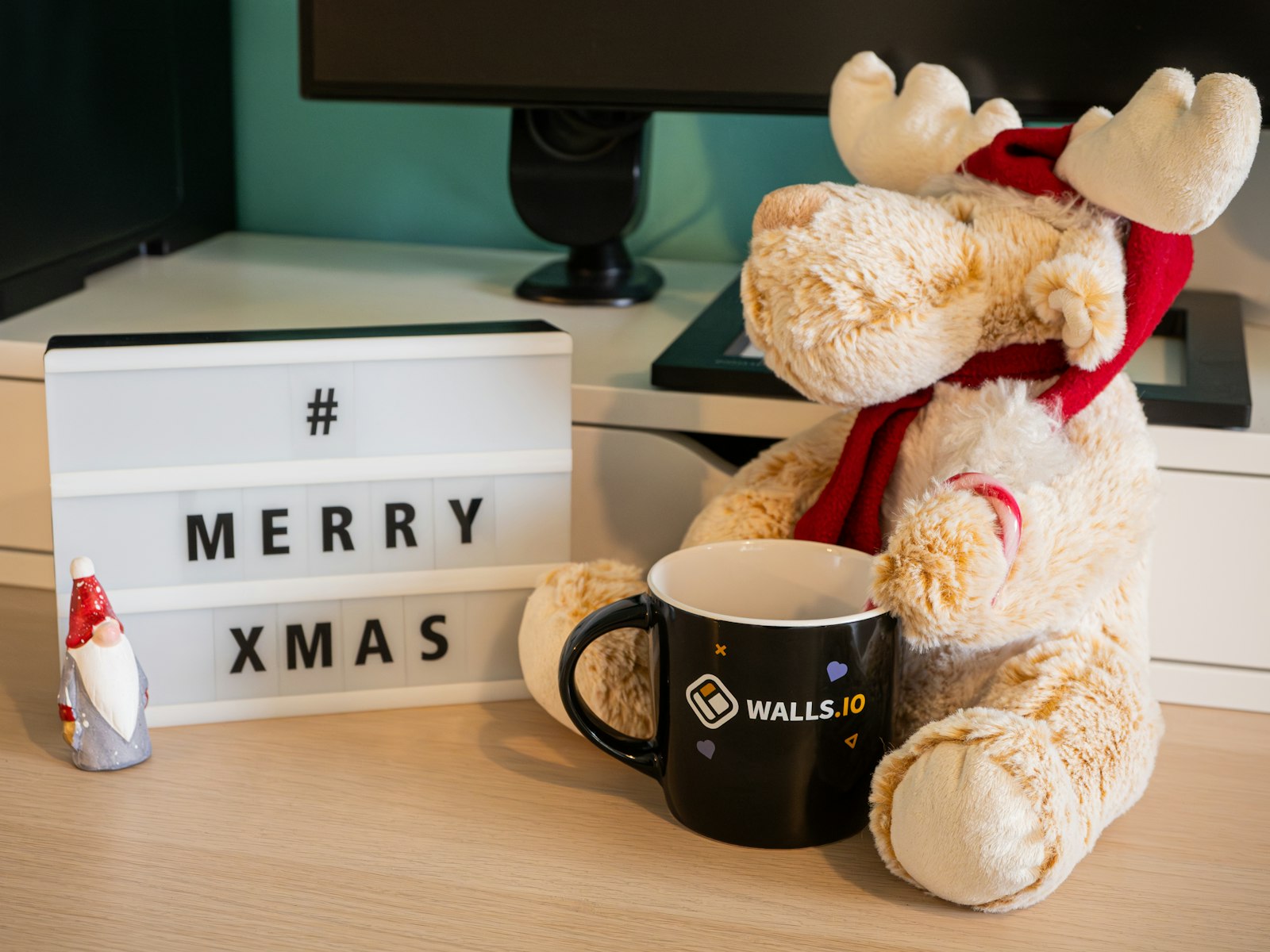 A teddy bear sitting next to a coffee mug – Christmas office decor idea