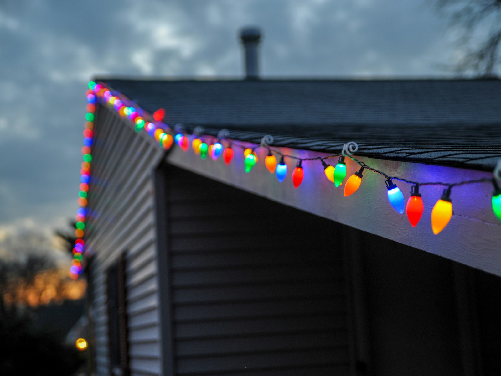Selective focus photography of string lights on roof top edge – Christmas outdoor decor idea