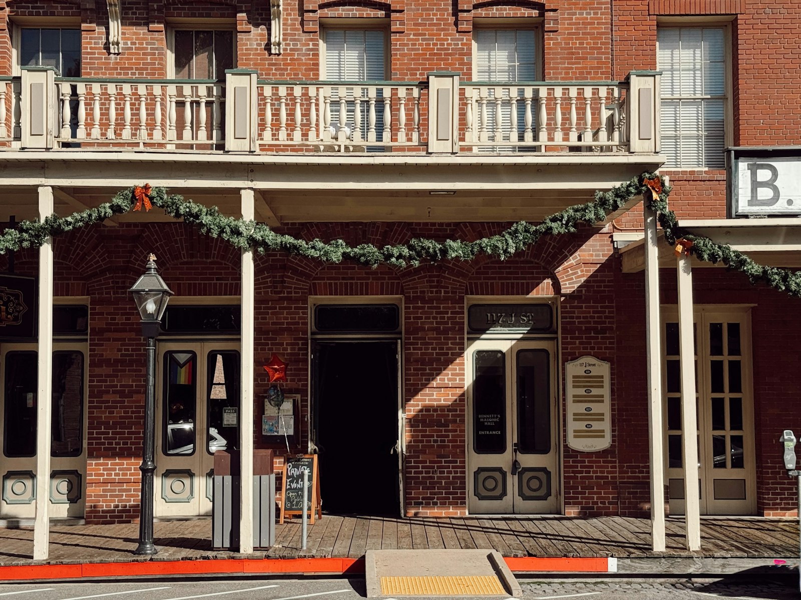 Old brick building with festive holiday garland decorations – Christmas outdoor decor idea
