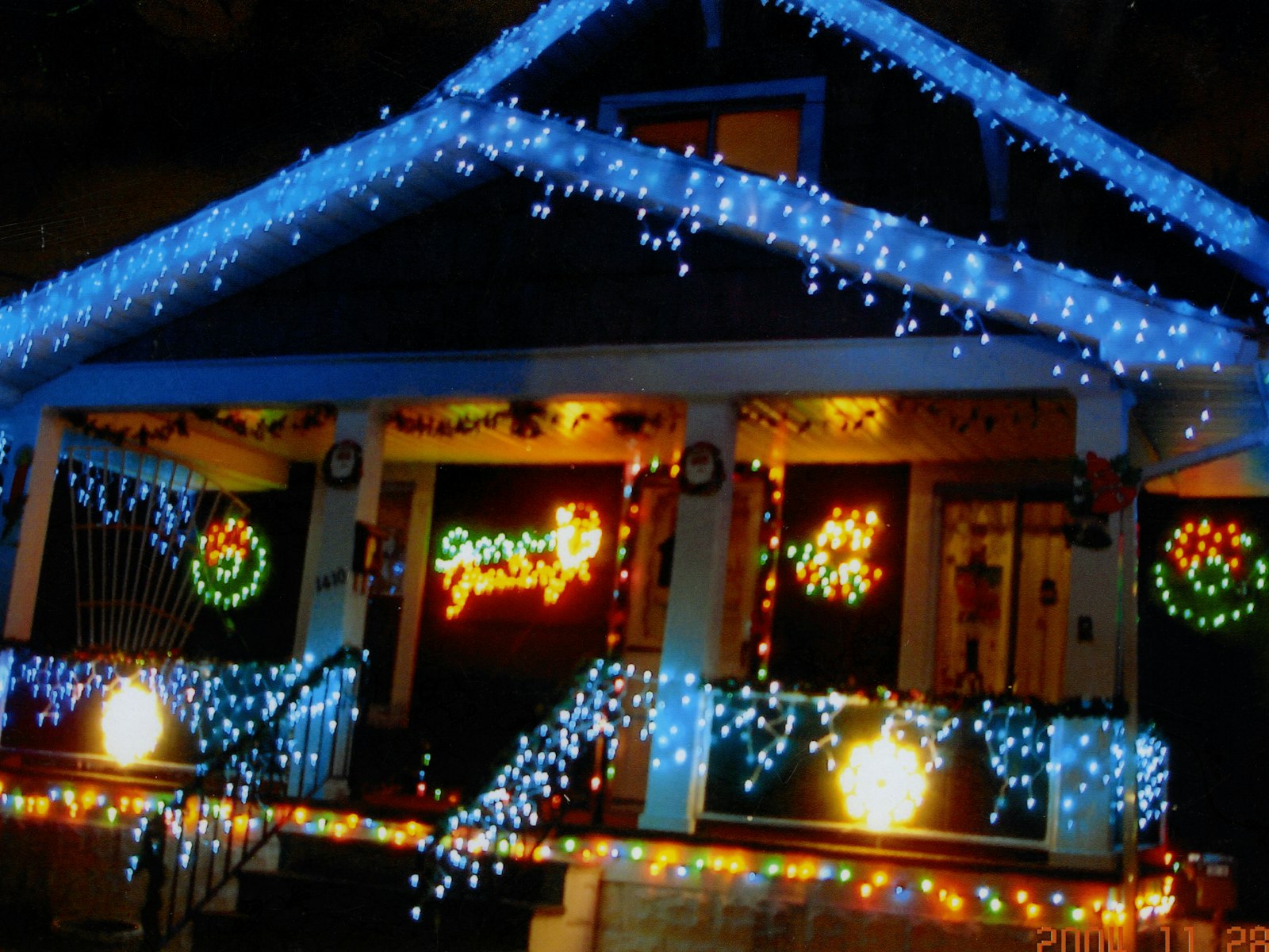 House brightly decorated with blue and multicolored christmas lights – Christmas outdoor decor idea
