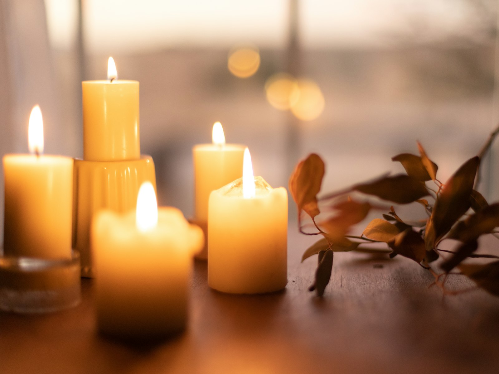 Cluster of lit pillar candles glowing on a table