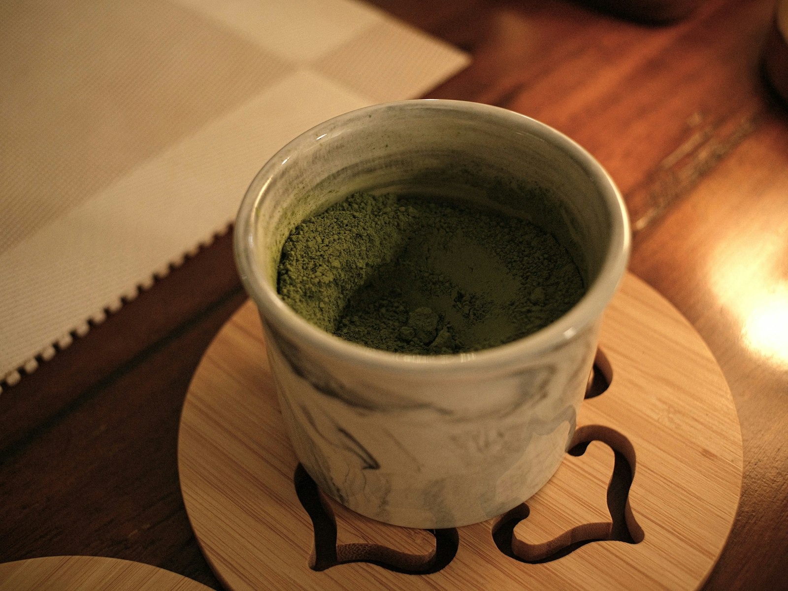 Handmade ceramic cup on a wooden coaster