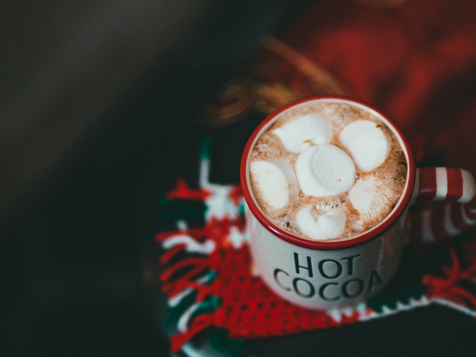 Mug of hot cocoa with marshmallows on a knit sweater