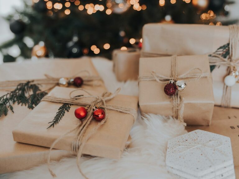 Kraft-wrapped Christmas gifts with ornaments and greenery