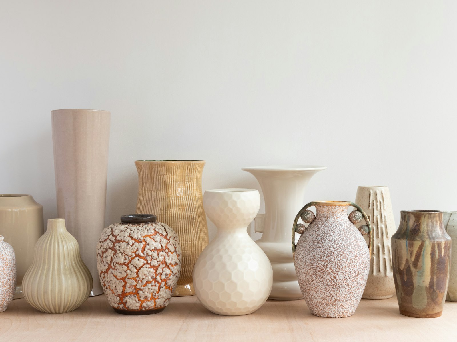 Collection of neutral ceramic vases on a shelf