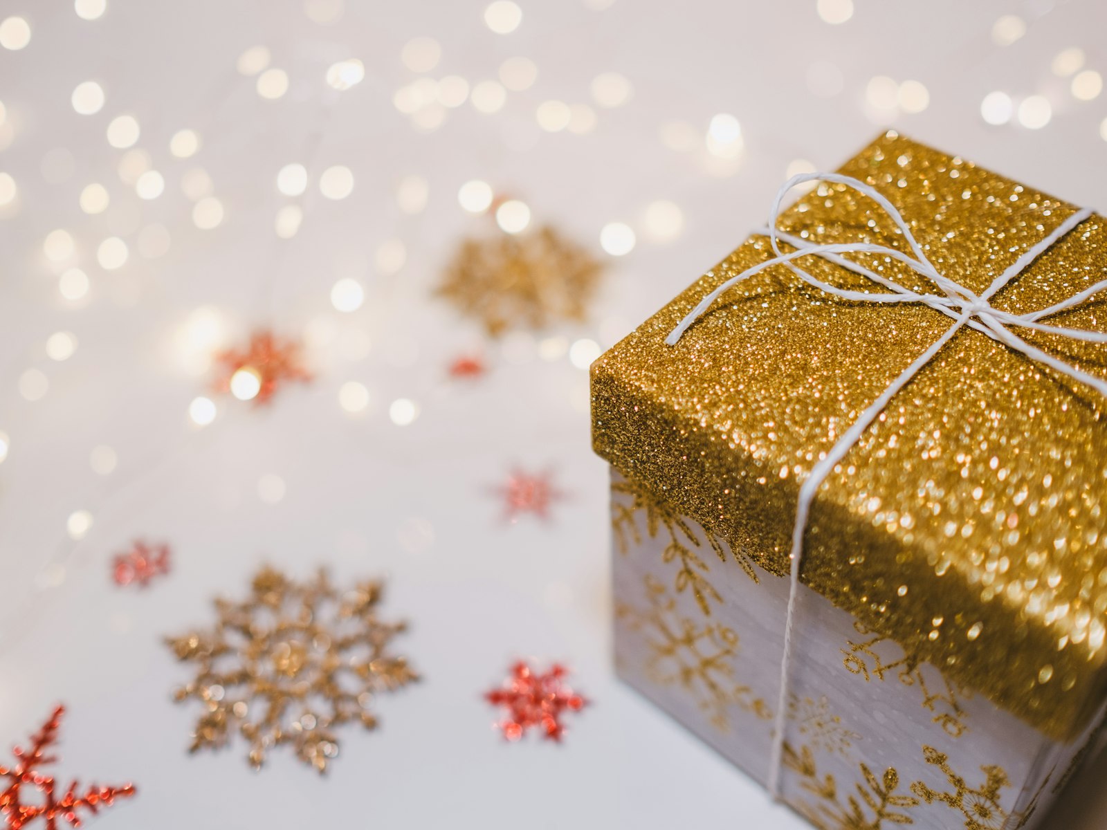 Small gold glitter gift box with snowflake decorations