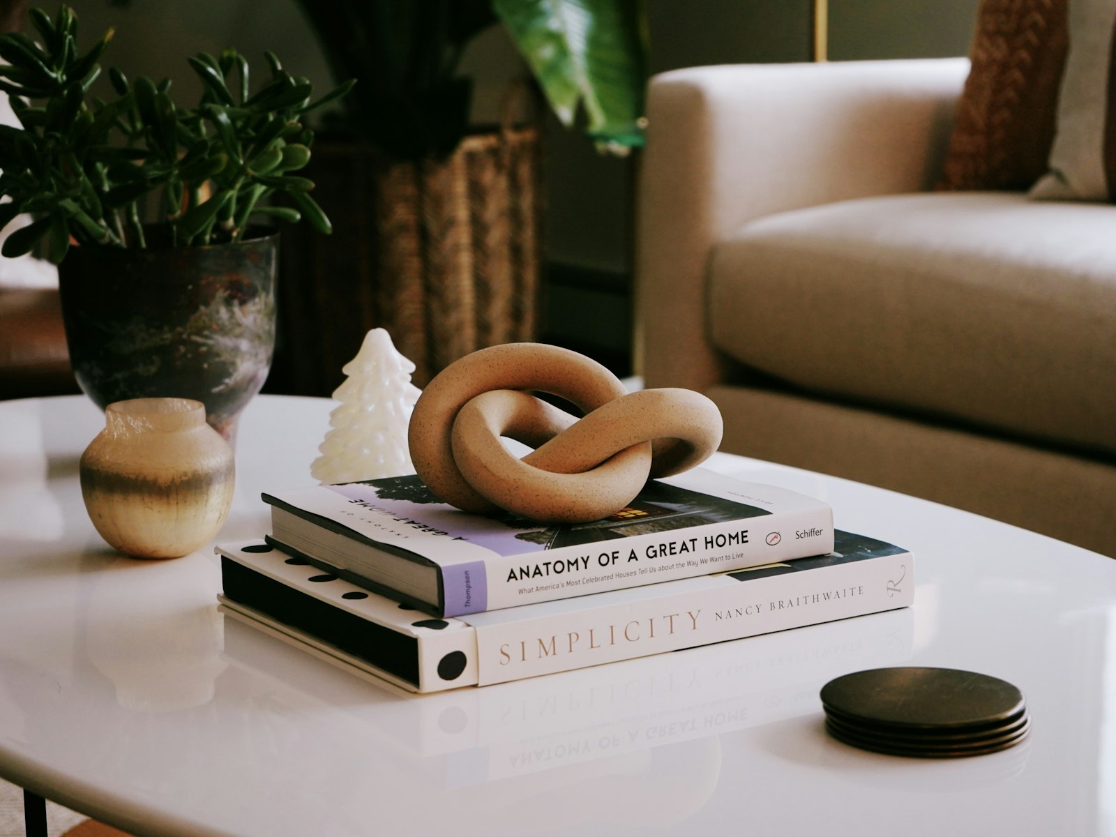 Coffee table styled with books, a ceramic knot and a plant