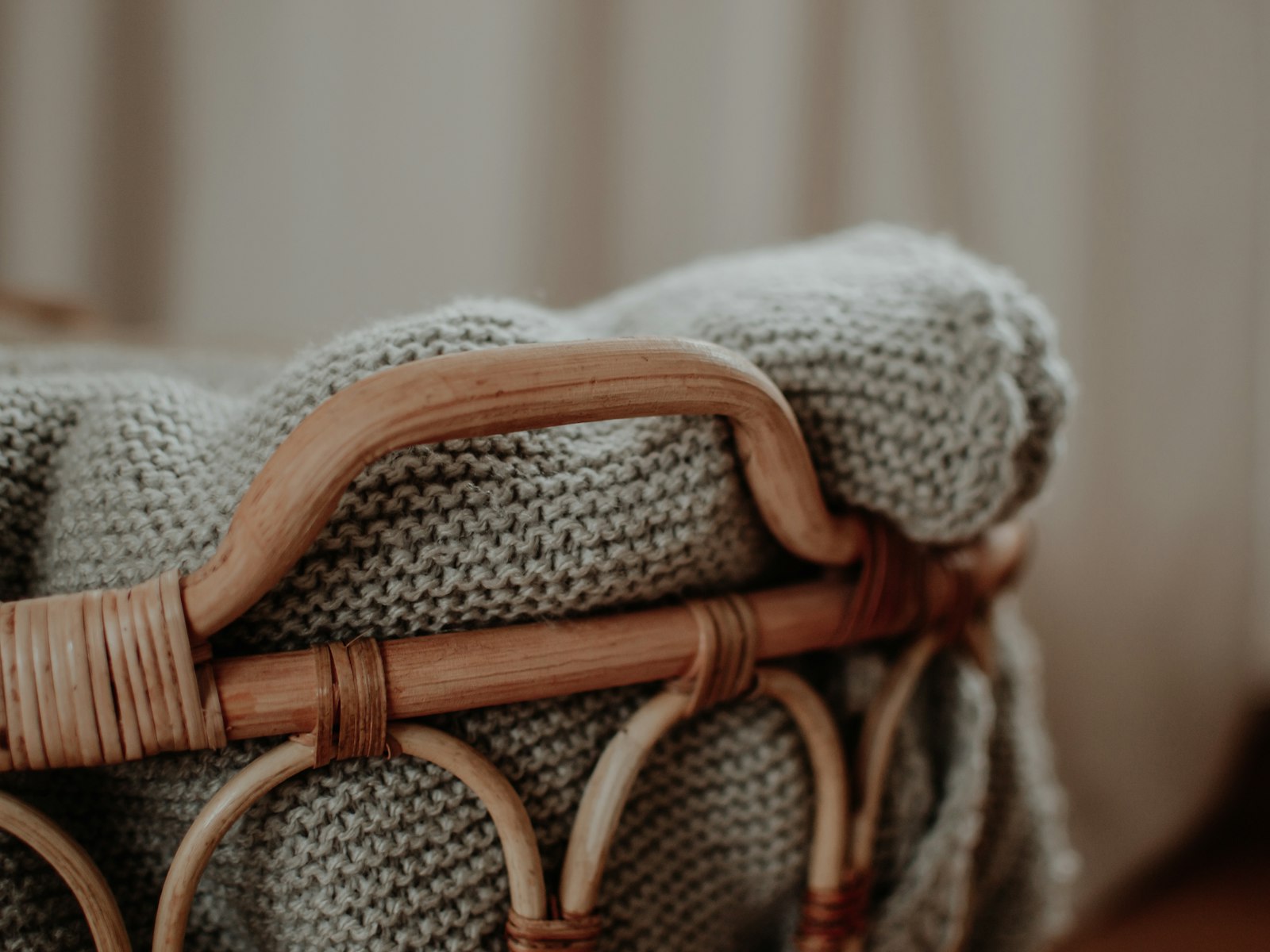 Knit blankets folded in a rattan basket