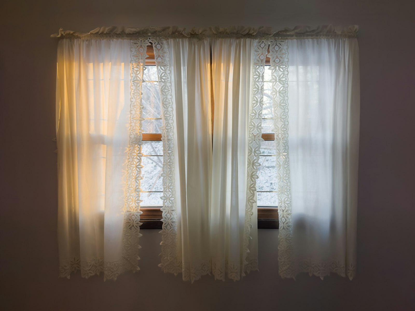 Sheer curtains glowing with warm evening light