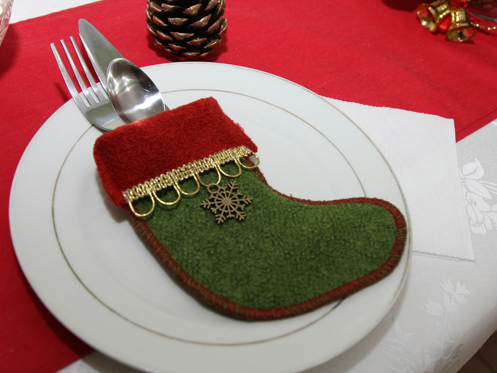 Mini felt stocking holding cutlery on a white Christmas plate