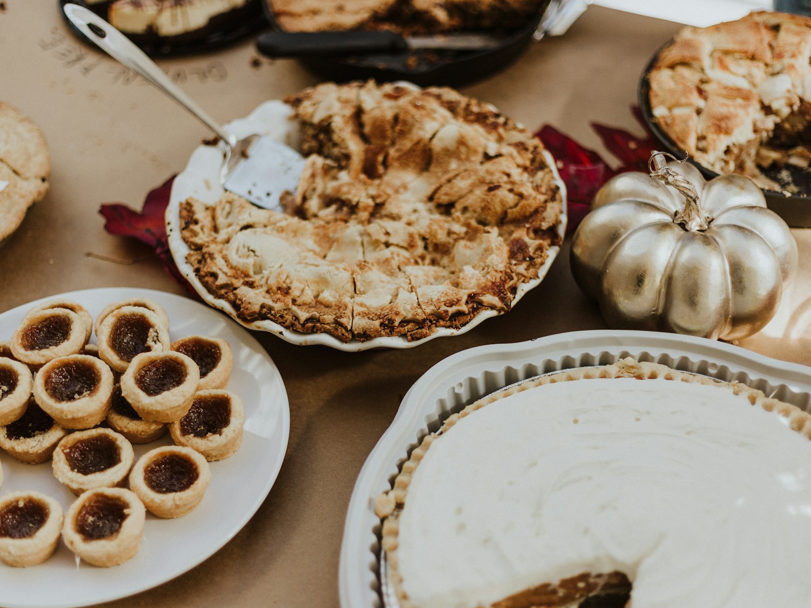 Thanksgiving dessert buffet with pies, butter tarts and a silver pumpkin