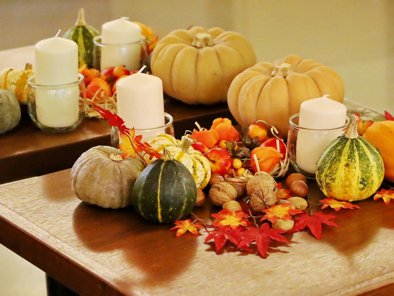 Warm terracotta Thanksgiving centerpiece of pumpkins, gourds and white candles