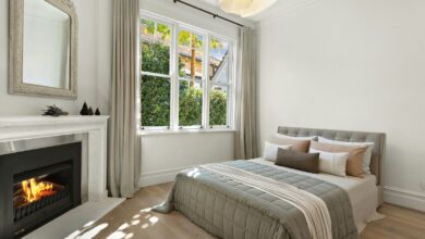 Winter bedroom with a fireplace, layered bedding and a wreath in the window