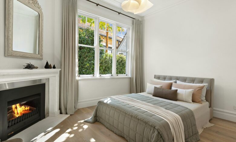 Winter bedroom with a fireplace, layered bedding and a wreath in the window