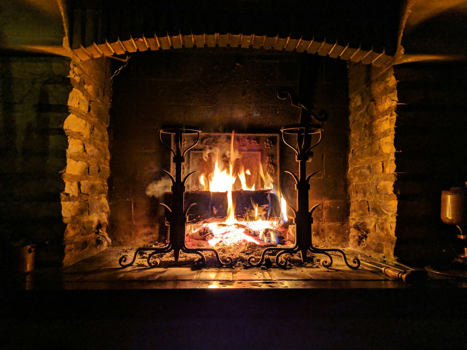 Wood fire burning in a brick fireplace, a reminder to keep garland clear of the opening
